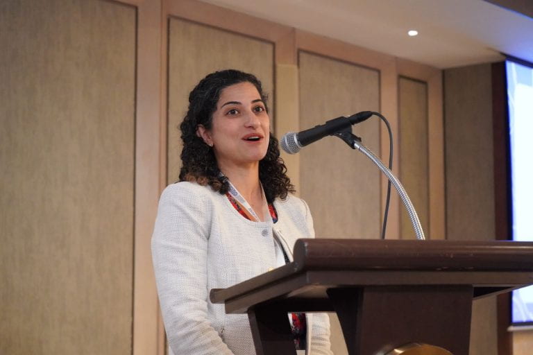 woman speaking at podium into microphone