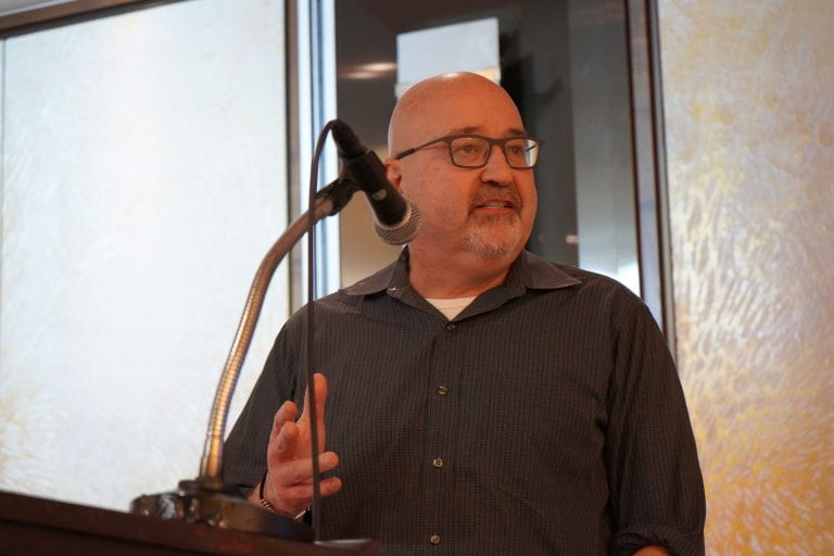 Person speaking at podium into microphone