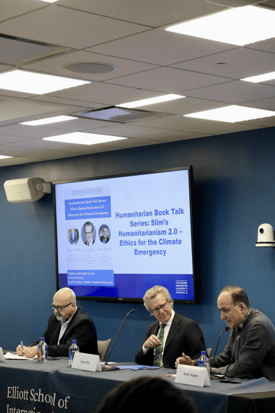 Three speakers sitting at table