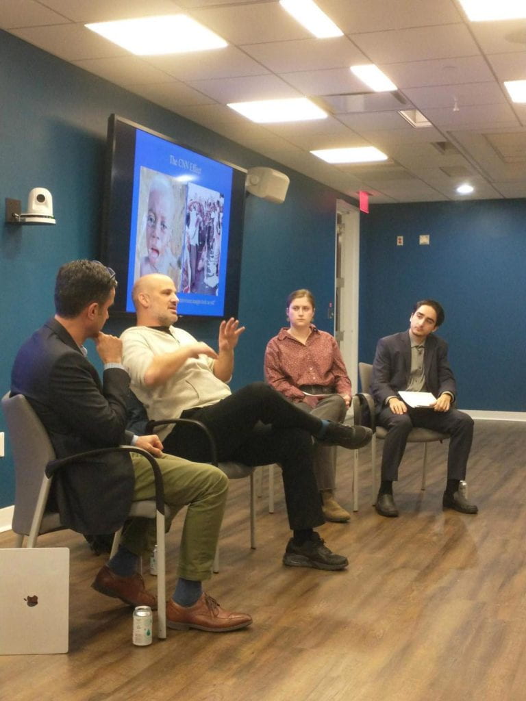 4 people sitting in chairs having a discussion