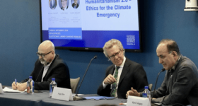 Three speakers sitting at table